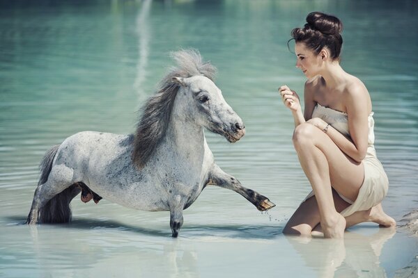 Ragazza e pony in acqua