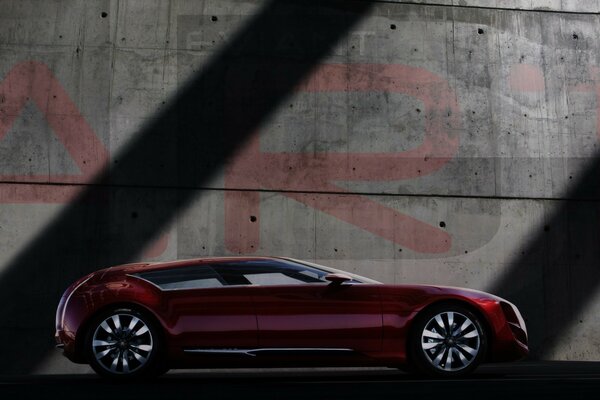 Coche rojo contra una pared gris