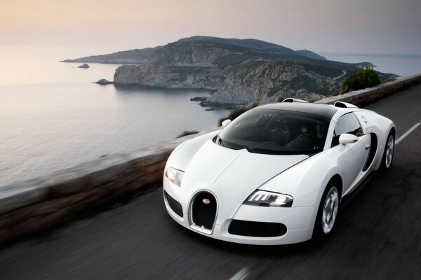 White bugatti rushes to the sea on the road