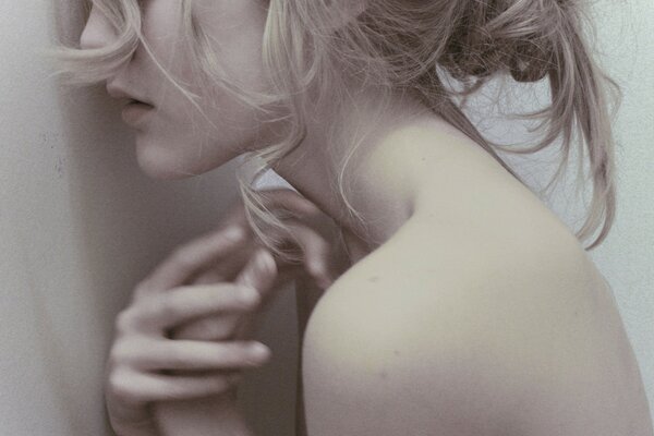 Ragazza con i capelli biondi con le mani sul viso