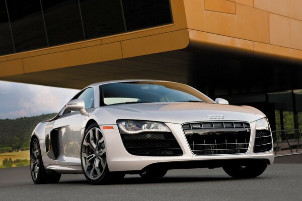 White Audi r8 drives through city streets