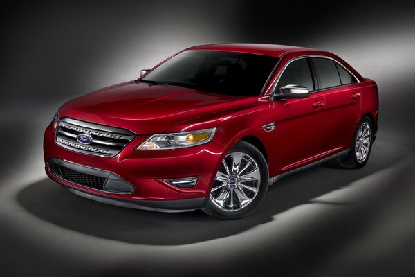 Luxus-Auto in roter Farbe auf grauem Hintergrund. Roter funkelnder Ford Taurus