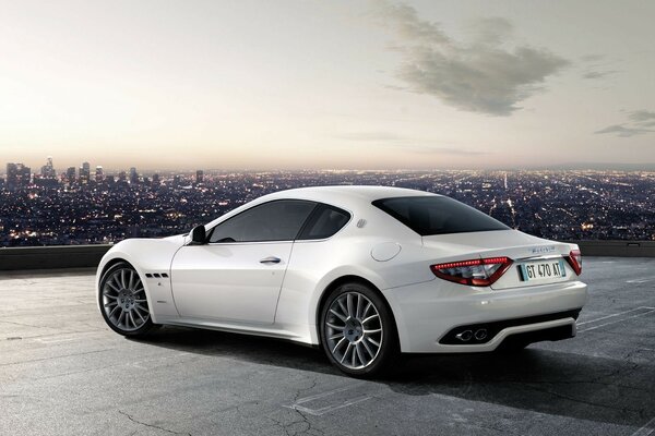 Maserati grandturismo blanco con vistas a la ciudad