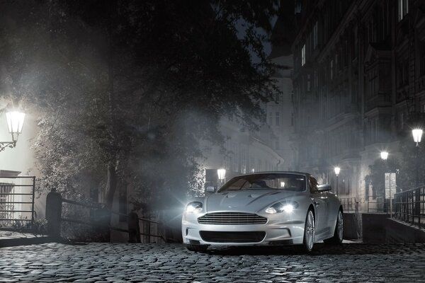 Aston Martin en una calle nocturna brumosa