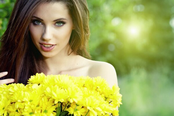 Belle femme avec des fleurs jaunes dans les mains