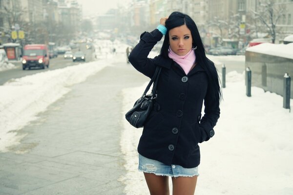 A girl stands in the middle of a snowy street