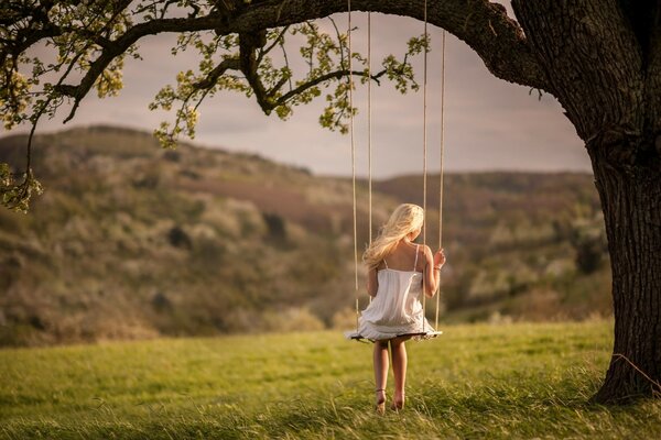 Ragazza in abito bianco su Swing