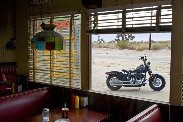 Harley davidson negro en la ventana de la cafetería de la carretera