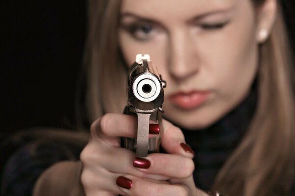 The girl takes aim holding a gun