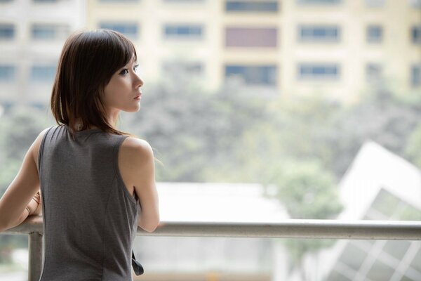 Fragile ragazza asiatica sul balcone