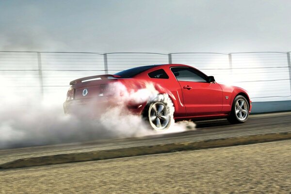 Red ford mustang in the smoke of its own wheels