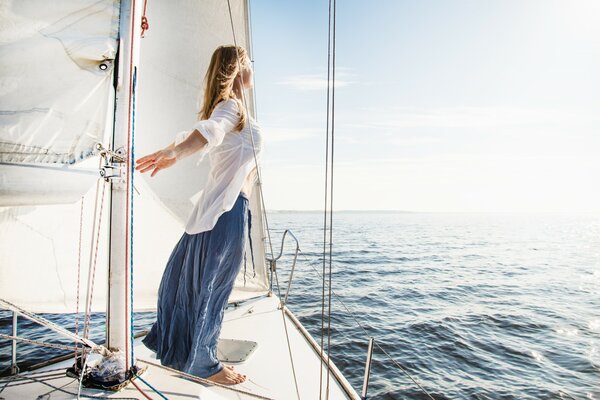 Una chica en un yate navega en un encuentro con el viento