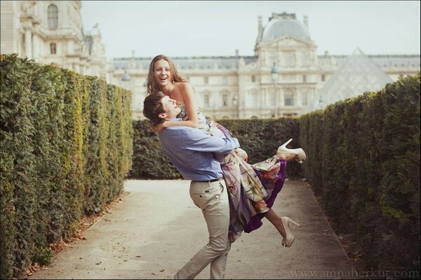 A guy is holding a beautiful girl in his arms