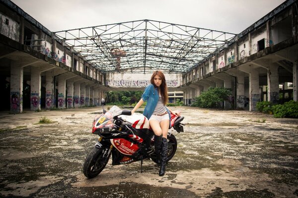 Moto Yamaha. Fille asiatique posant sur fond