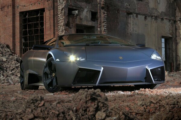 Coche lamborghini, reverton, negro. Vista frontal. En las ruinas