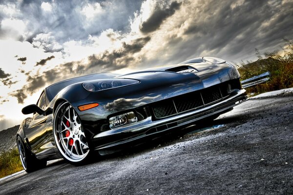 Chevrolet Corvette en asfalto gris, coche bajo el cielo nublado