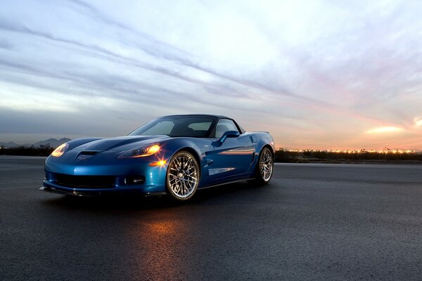 Coche azul en el fondo de la puesta de sol