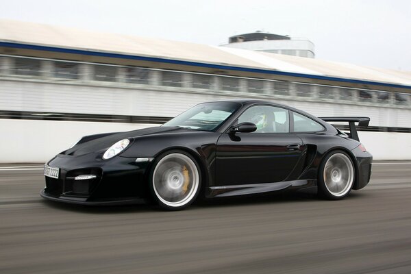 Porsche 911 nera che corre sul circuito