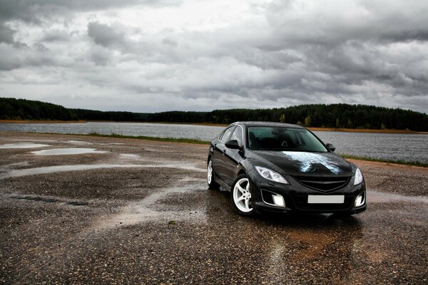 Black car with airbrushing on lake background