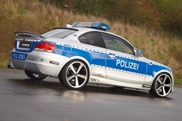 Weiß-blaues Polizeiauto auf nasser Straße