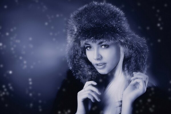 Beautiful girl in a warm hat in winter