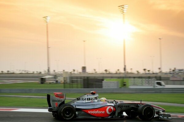 Voiture de formule un sur la piste au coucher du soleil