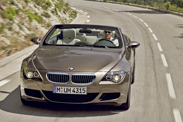 Brown BMW on a hilly road