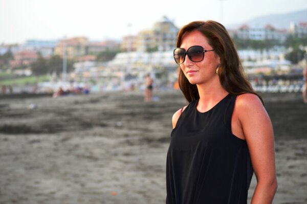 Brunette in a black dress and sunglasses