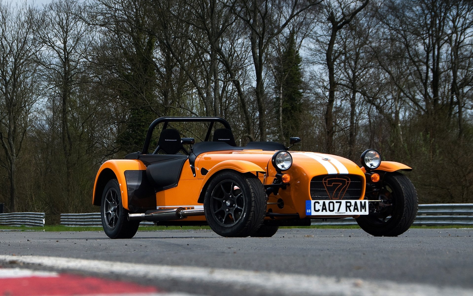 caterham sieben supersport schnellboot sieben supersportwagen orange front rennstrecke bäume hintergrund