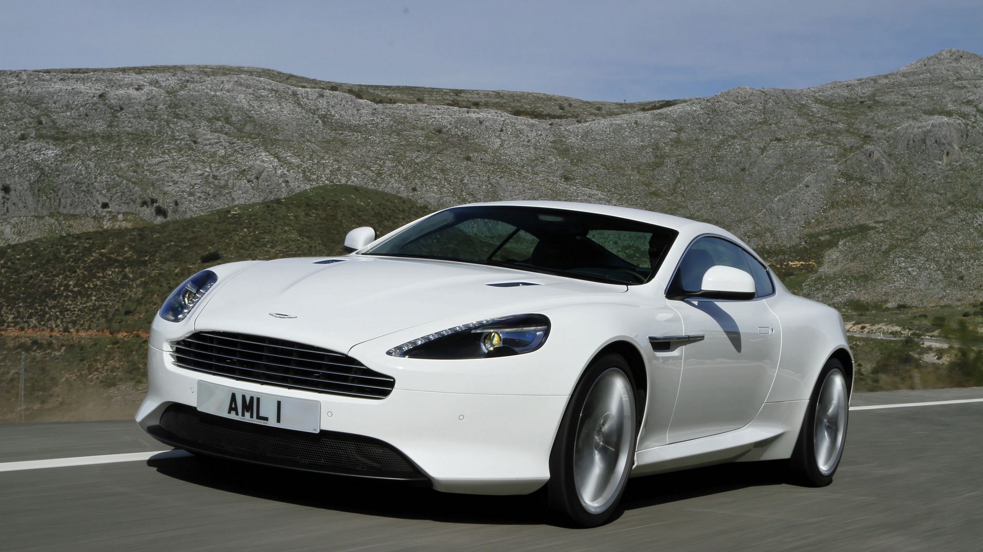 aston martin giro coupé paisaje cielo montañas carretera