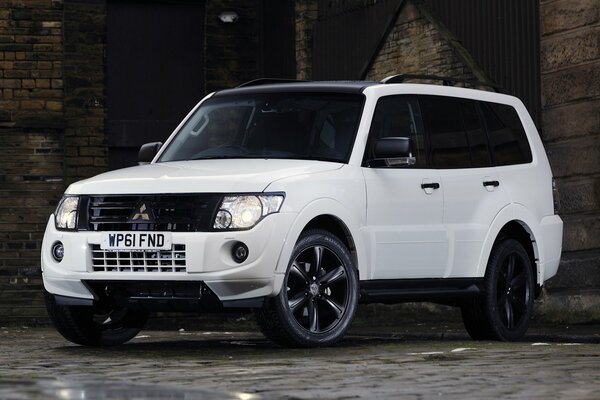 A white Mitsubishi car stands on a dark background