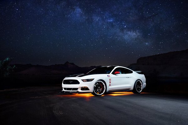 Ford Mustang de color blanco contra el cielo estrellado