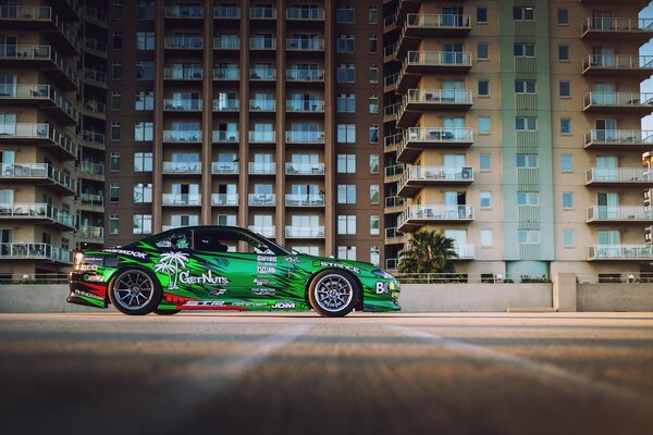 Green car on the background of city buildings