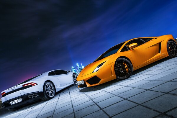 White and orange Lamborghini on the background of the lights of the night city of Moscow