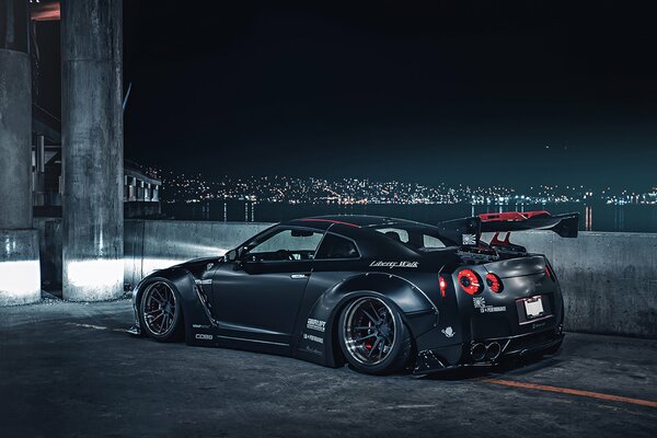 Nissan sport gris sur fond de ville de nuit