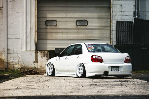 White Subaru Impreza Next to the old garage