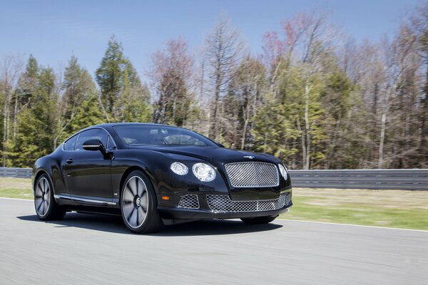 Bentley noir en mouvement sur une route de campagne