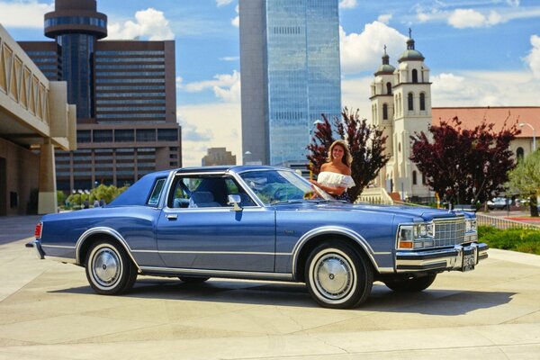 A beautiful 1979 car on the background of a church, and a beautiful girl 