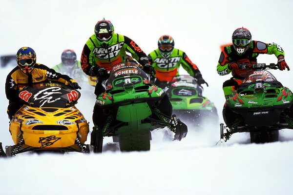 Atletas de carreras de motos de nieve con cascos