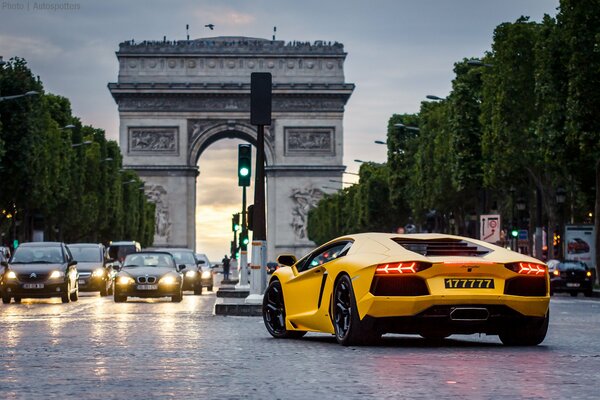 Gelbes Lamborghini-Auto auf dem Hintergrund einer viel befahrenen Straße