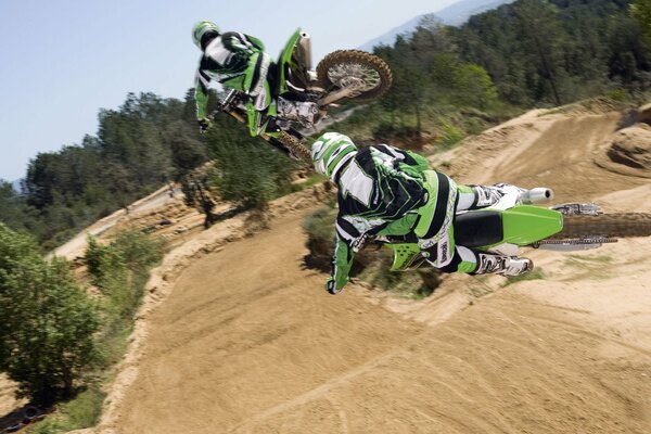 Sand track motocross bikers in flight