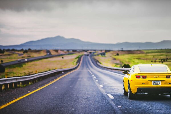 Viajar por las carreteras de montaña es más interesante en un camaro amarillo