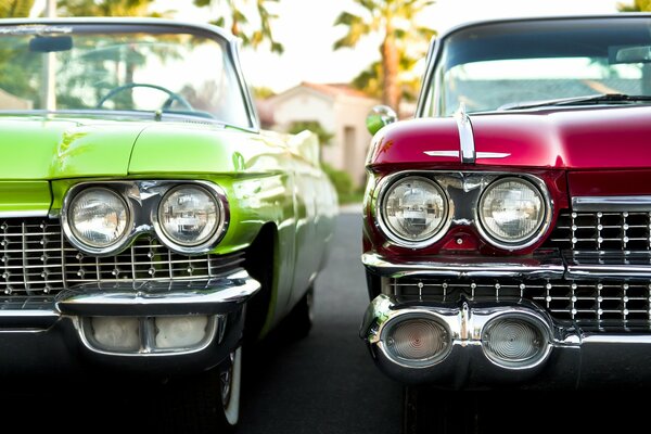 Two cars of red and green colors are standing next to each other