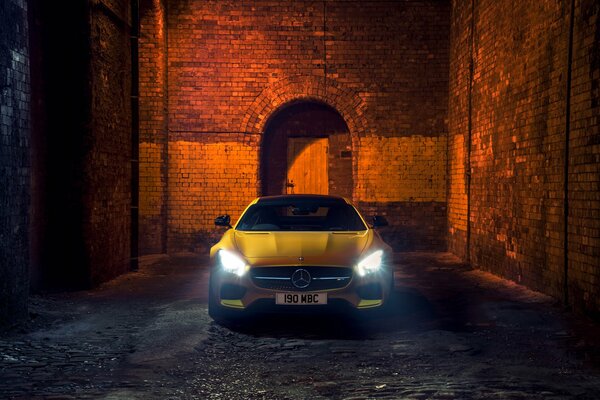 El coche amarillo se encuentra contra una pared de ladrillo