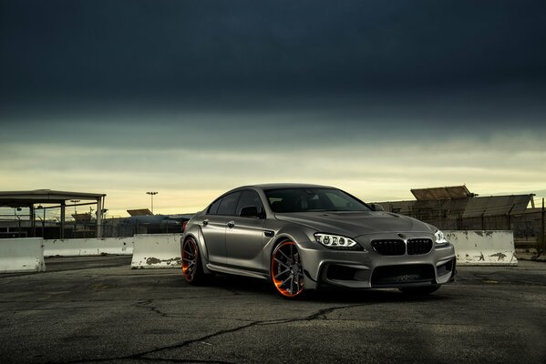 Grey matte bmw m6 on the background of the sky and buildings