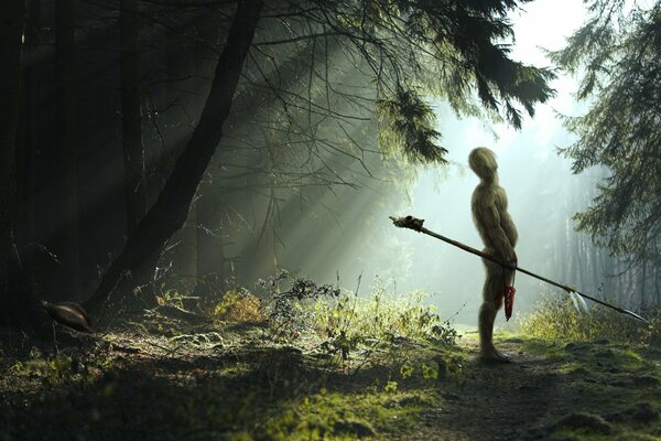 Homme avec une lance sur fond de forêt dense