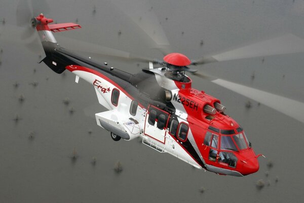 A cougar helicopter flies over numerous rocks