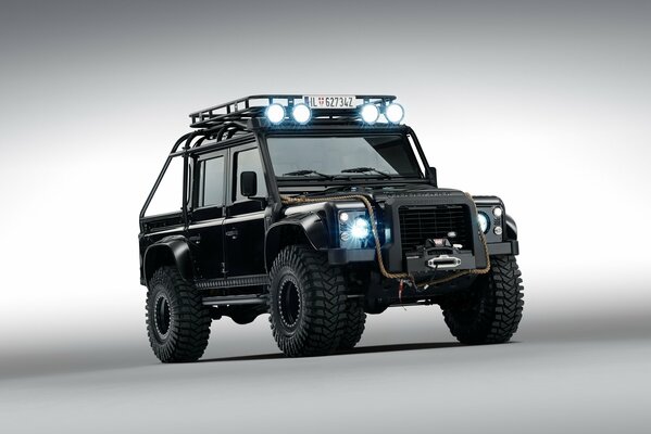 Coche de Land Rover Defknder con los faros encendidos