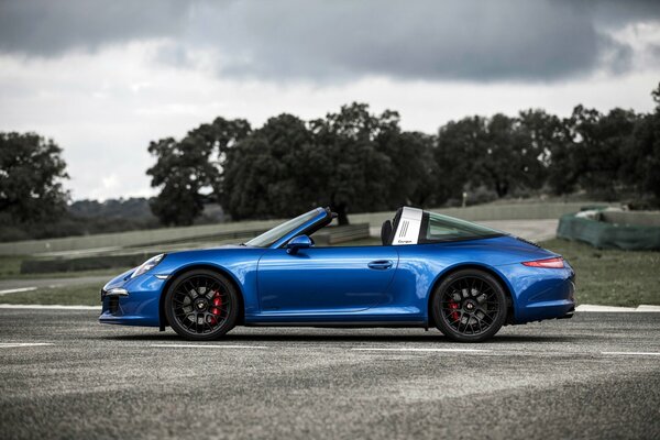 Porsche bleu sur fond de temps gris