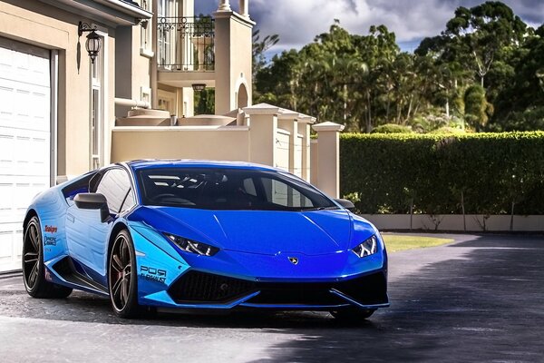 Blue Lamborghini near a luxury house